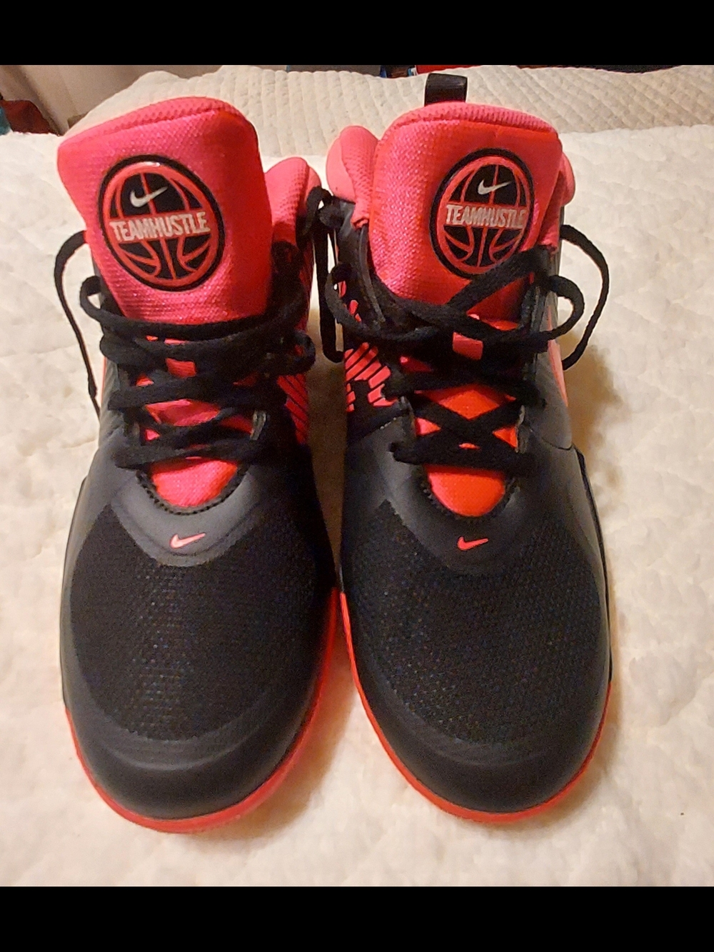 Nike Team Hustle D 9 basketball shoes in a black and pink colorway
